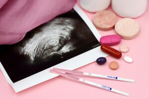 photo of sonogram, pregnancy test strips, and vitamins